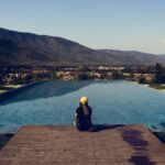 woman sitting by poolside wiht mountain view