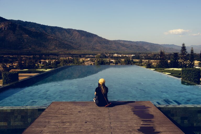 woman sitting by poolside wiht mountain view